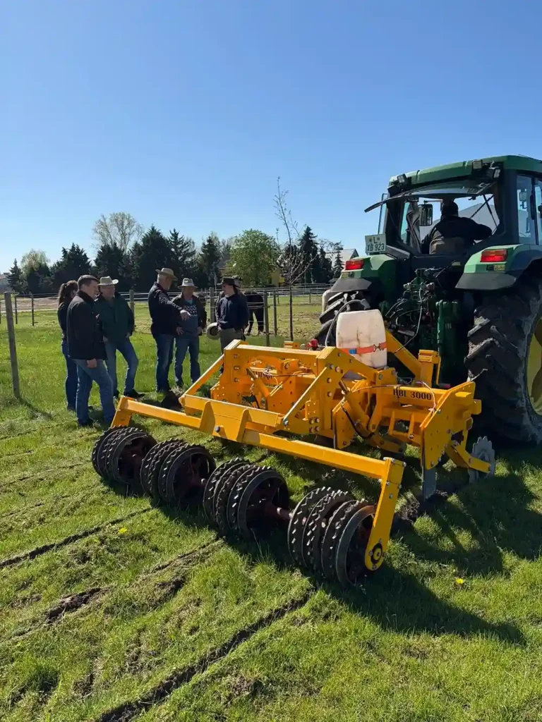 Feldtag mit Landwirten, Traktor und Bodenbearbeitungsgerät auf einer landwirtschaftlichen Fläche